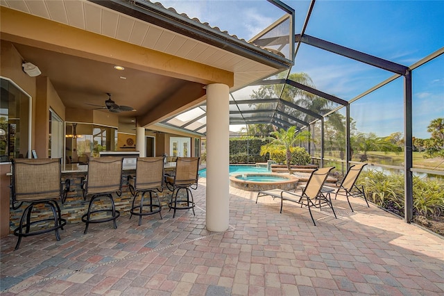 view of patio / terrace with glass enclosure, ceiling fan, an in ground hot tub, a water view, and a bar