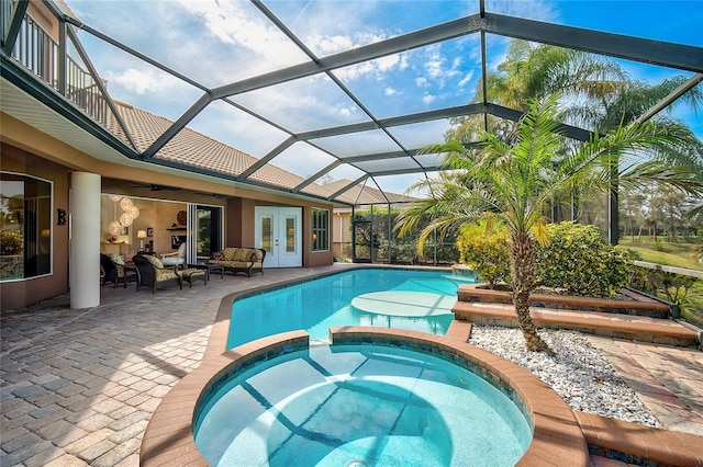 view of pool with an in ground hot tub, french doors, ceiling fan, glass enclosure, and a patio