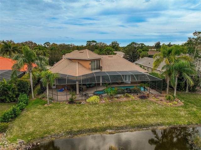 back of property featuring a lanai, a yard, a patio, and a water view