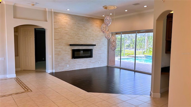 2123 Calusa Lakes Blvd, Nokomis, FL 34275 - unfurnished living room featuring a fireplace, baseboards, arched walkways, recessed lighting, and tile patterned flooring