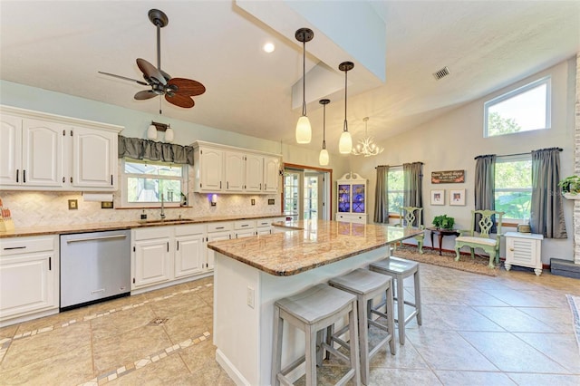 kitchen featuring stainless steel dishwasher, ceiling fan with notable chandelier, a center island, and white cabinetry