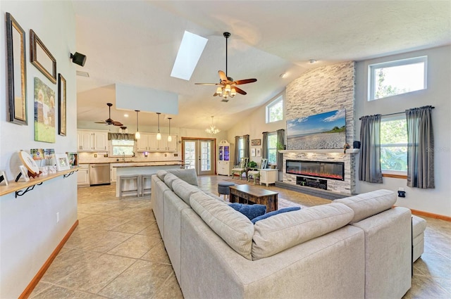 living room featuring high vaulted ceiling, a stone fireplace, a wealth of natural light, and light tile patterned flooring