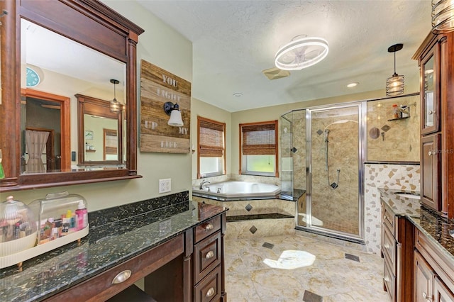 bathroom featuring vanity, a textured ceiling, and independent shower and bath