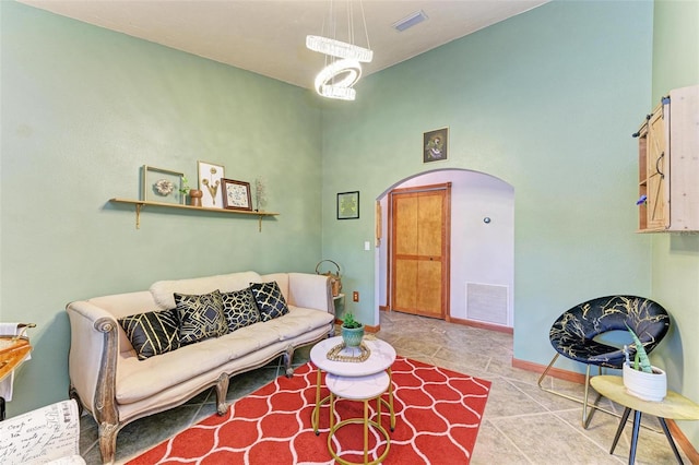 tiled living room featuring a chandelier