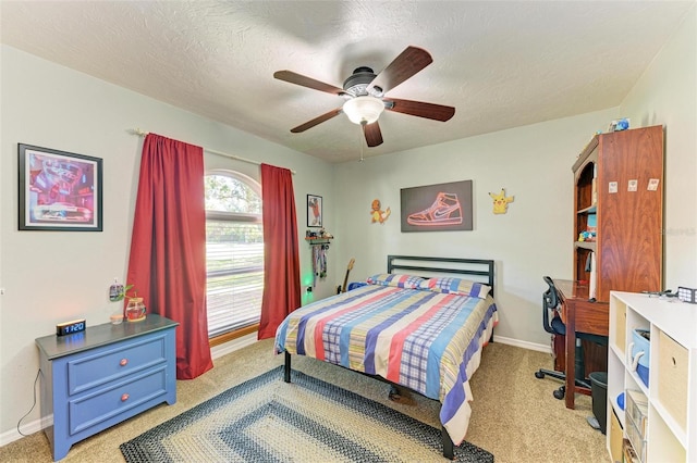 bedroom featuring a textured ceiling, ceiling fan, and light carpet