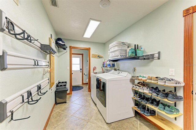 laundry room featuring light tile patterned floors and washing machine and clothes dryer