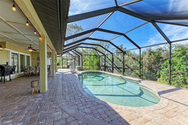 view of pool featuring glass enclosure, ceiling fan, a patio area, and area for grilling