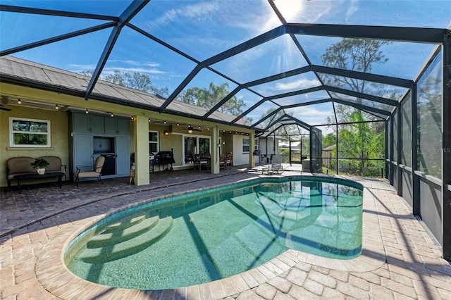 view of pool with ceiling fan, a grill, a patio, and glass enclosure