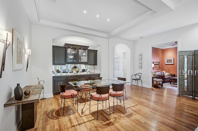 dining space with a tray ceiling and light hardwood / wood-style floors