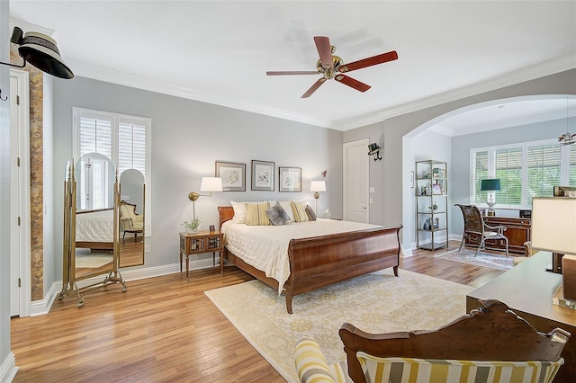 bedroom with multiple windows, ceiling fan, crown molding, and light wood-type flooring