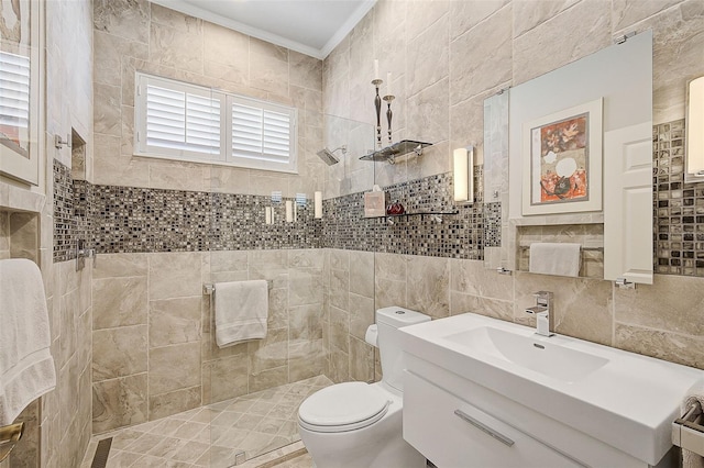 bathroom featuring a tile shower, toilet, vanity, tile walls, and ornamental molding