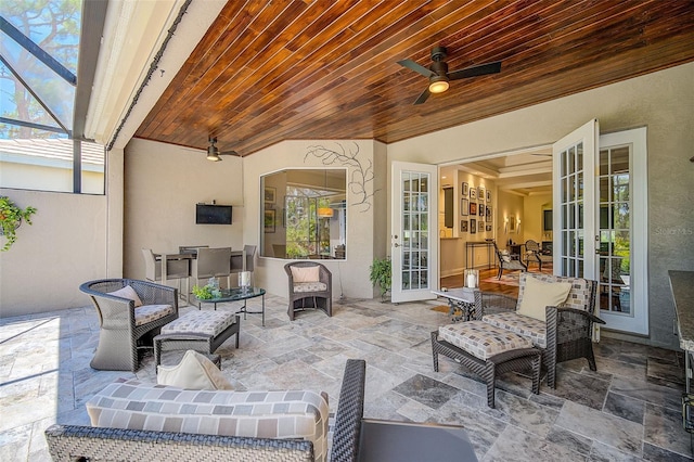 view of patio / terrace featuring french doors, ceiling fan, and a lanai