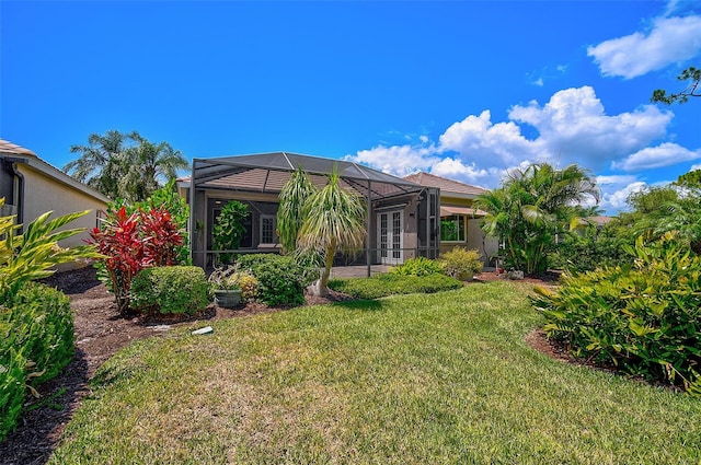 rear view of property with a yard and a lanai