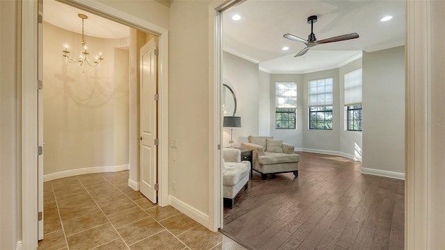 hallway featuring crown molding, hardwood / wood-style flooring, and an inviting chandelier