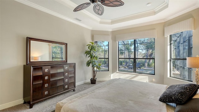 carpeted bedroom featuring ceiling fan, a raised ceiling, and ornamental molding