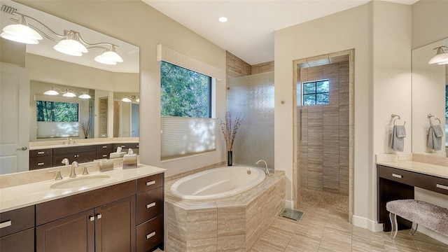 bathroom featuring plus walk in shower, vanity, and tile patterned flooring