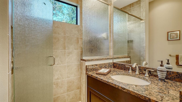 bathroom featuring vanity and a shower with door