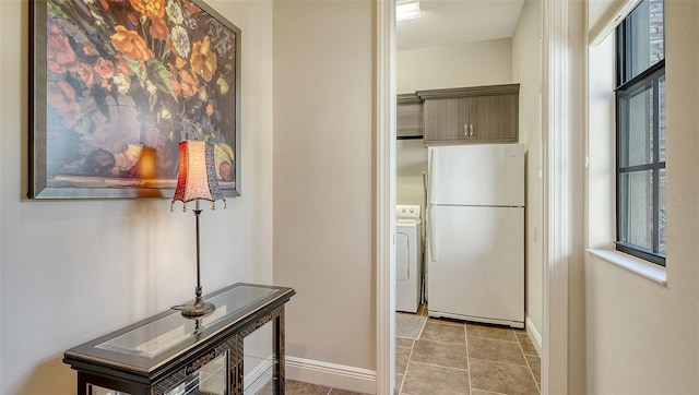 corridor with a wealth of natural light, light tile patterned floors, and washer / clothes dryer