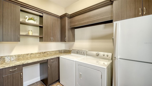 washroom featuring cabinets, independent washer and dryer, and tile patterned floors