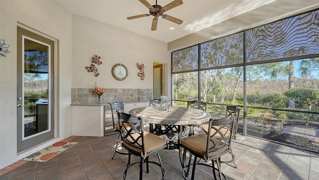 sunroom with ceiling fan and sink