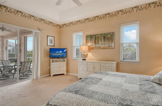 bedroom featuring a tray ceiling, a ceiling fan, light carpet, access to outside, and baseboards