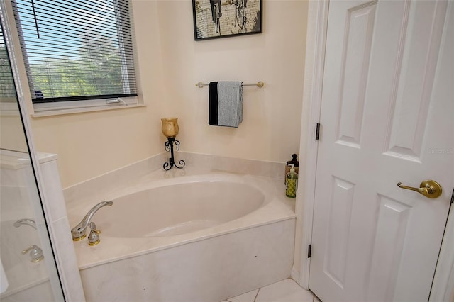 bathroom with tile patterned flooring and a bath