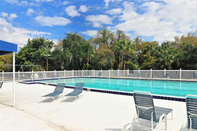 pool featuring fence and a patio