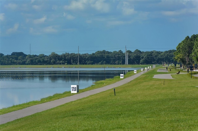 surrounding community with a water view and a yard