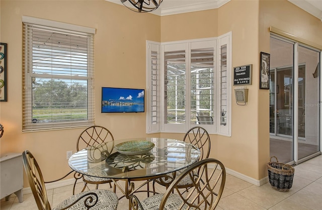 dining room featuring crown molding, baseboards, and light tile patterned floors