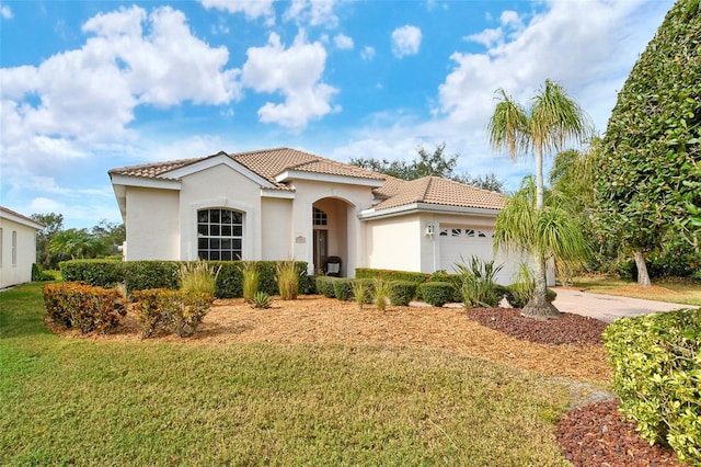 mediterranean / spanish home with a front yard, a tiled roof, an attached garage, and stucco siding