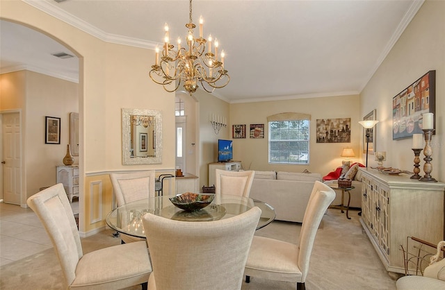 dining area featuring light carpet, visible vents, arched walkways, and crown molding