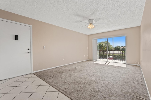 tiled empty room with ceiling fan and a textured ceiling