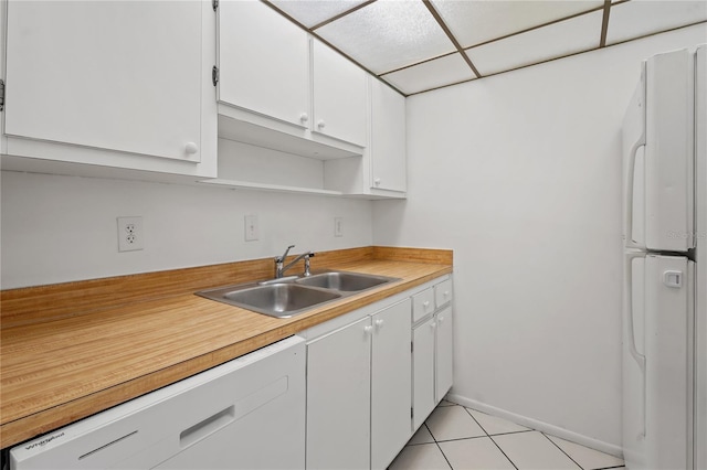 kitchen featuring white cabinets, white appliances, sink, and light tile patterned floors