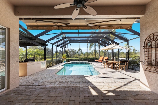 view of swimming pool with an outdoor kitchen, ceiling fan, a lanai, and a patio