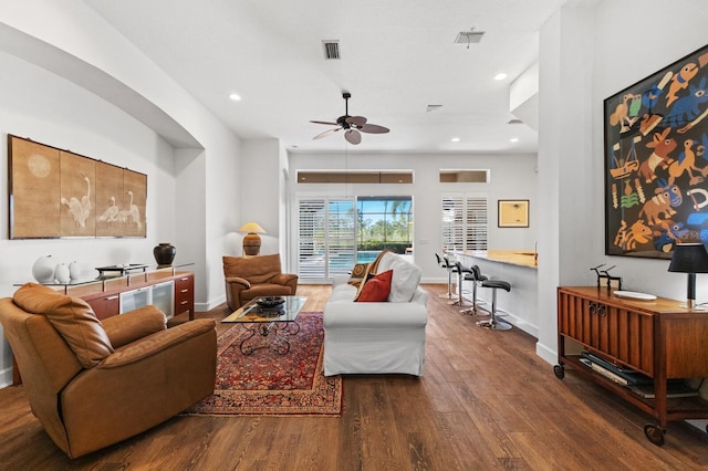 living room with dark hardwood / wood-style floors and ceiling fan