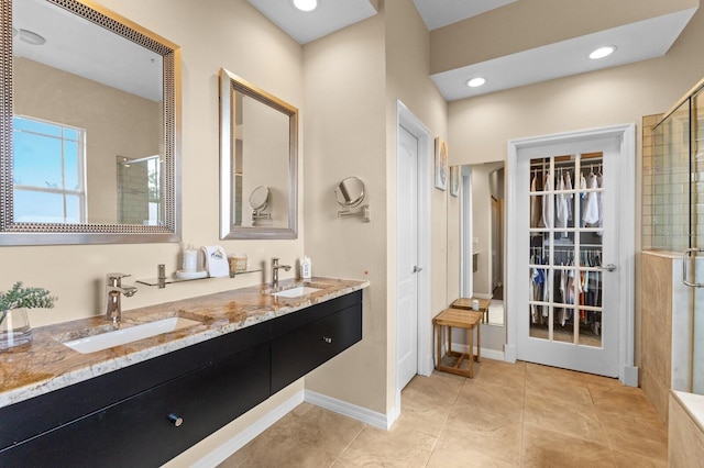 bathroom featuring tile patterned flooring, vanity, and walk in shower