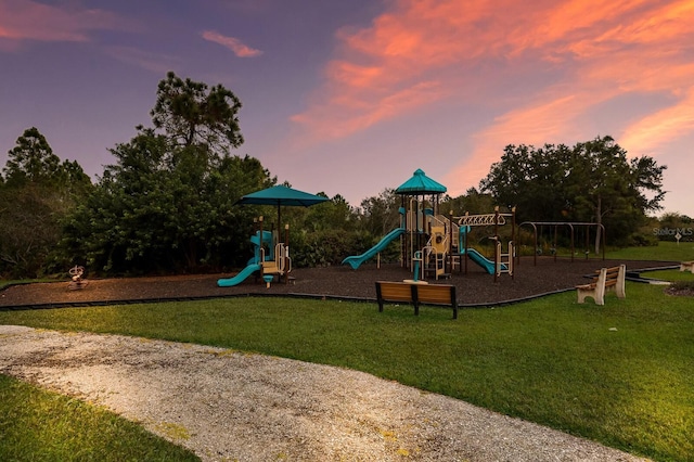 playground at dusk featuring a yard