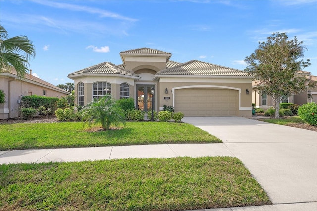 mediterranean / spanish-style house with a front lawn, a garage, and french doors