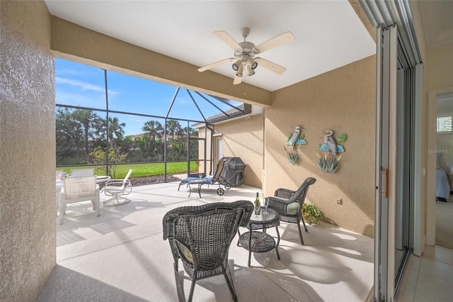 view of patio / terrace with a lanai, area for grilling, and ceiling fan