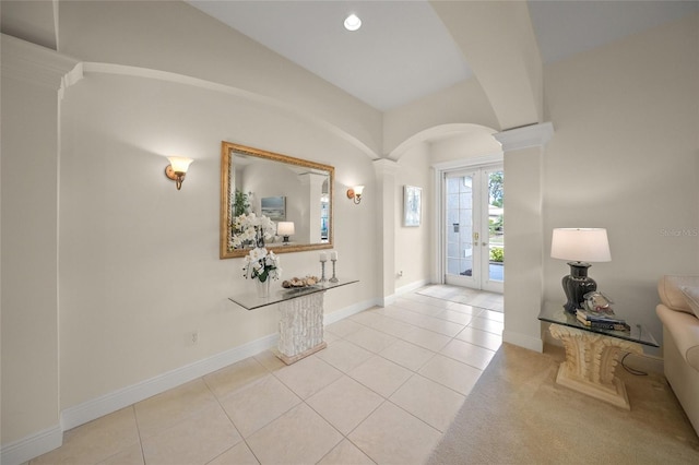 tiled entrance foyer featuring lofted ceiling, french doors, and decorative columns