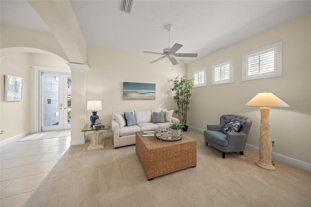 tiled living room with ceiling fan, a healthy amount of sunlight, and decorative columns