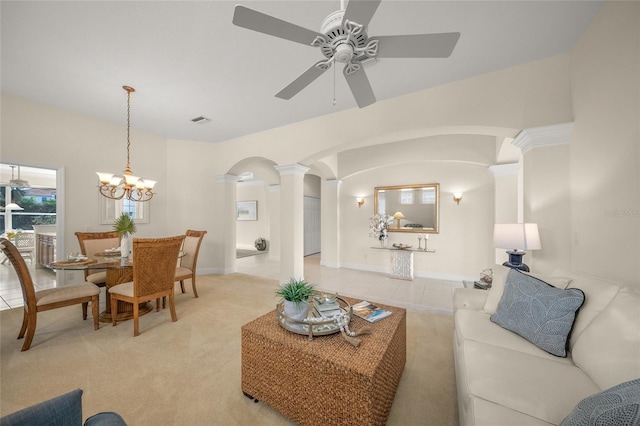 living room with decorative columns, light colored carpet, and ceiling fan with notable chandelier