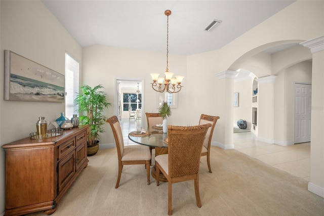 dining room with decorative columns, light carpet, and a chandelier