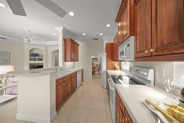 kitchen featuring built in shelves, white appliances, crown molding, sink, and light tile patterned floors