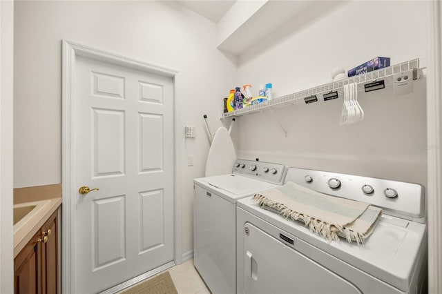 washroom featuring separate washer and dryer, light tile patterned floors, and cabinets