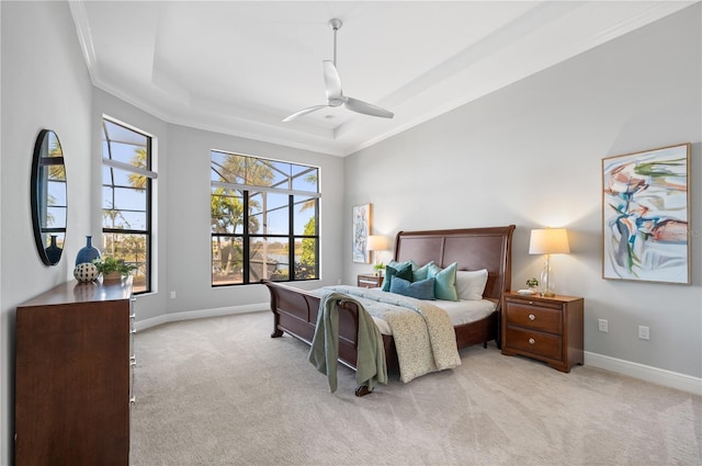 carpeted bedroom featuring ceiling fan, a tray ceiling, and crown molding