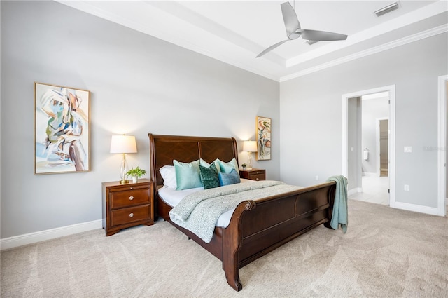 carpeted bedroom featuring ceiling fan, ensuite bathroom, a raised ceiling, and crown molding