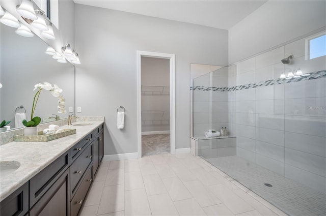 bathroom with tiled shower and vanity