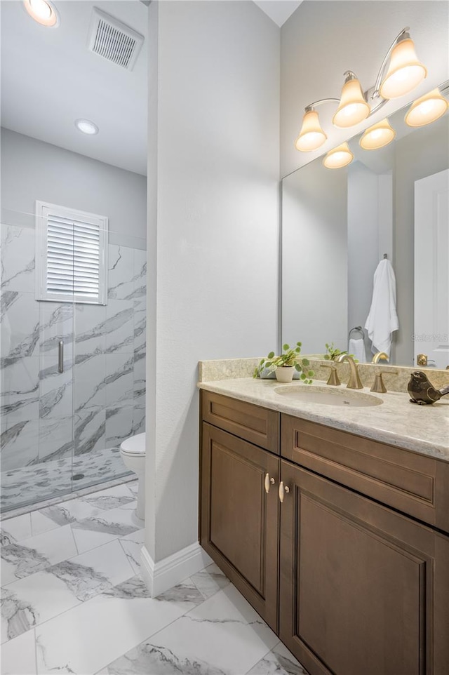 bathroom featuring vanity, toilet, and a shower with door