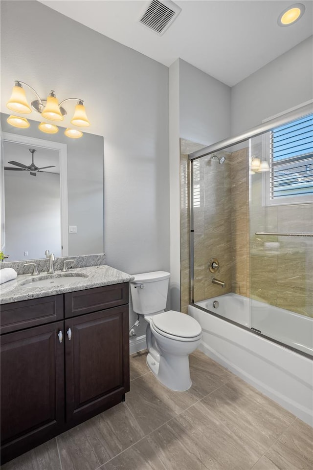 full bathroom featuring tile patterned floors, vanity, bath / shower combo with glass door, toilet, and ceiling fan